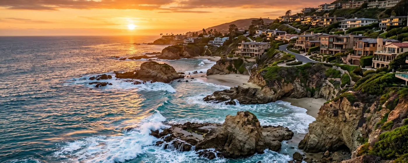 Buy a home in Laguna Beach CA — get 1% cash back at closing Laguna Beach dramatic rocky Pacific coastline with hillside homes overlooking turquoise ocean at sunset — Portfolio Home Realty buyer agent